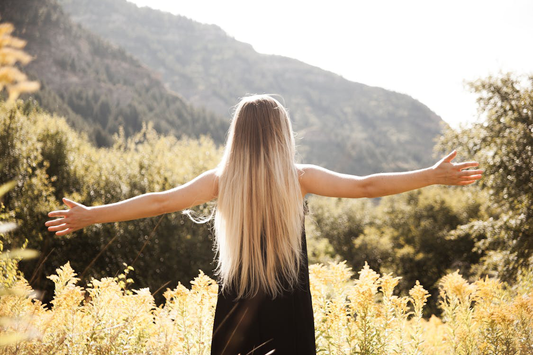 A woman with long hair facing the mountain.