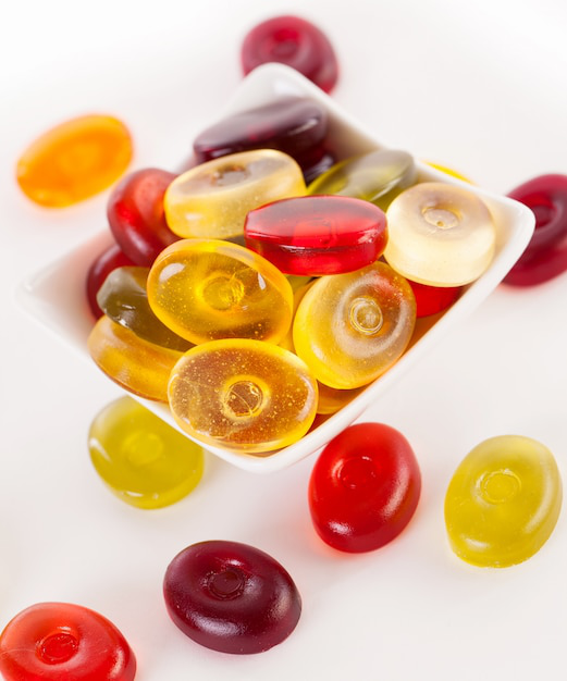 A clear container filled with a variety of colorful collagen gummies.